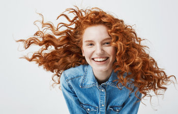 red haired girl in a jeans shirt laughs