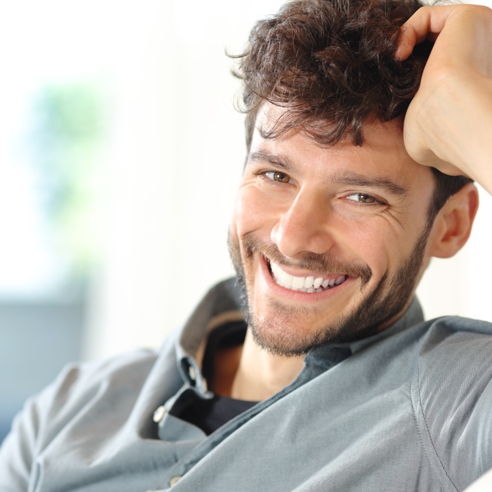 Portrait of a happy man with perfect smile looking at camera at home