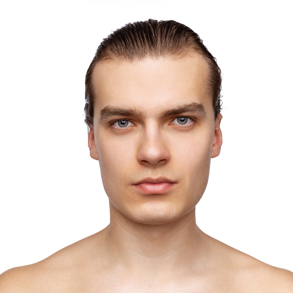 Male beauty. Close-up portrait of young handsome man isolated on white studio background. Concept of men's health, self-care, body and skin care. Male model looking at camera