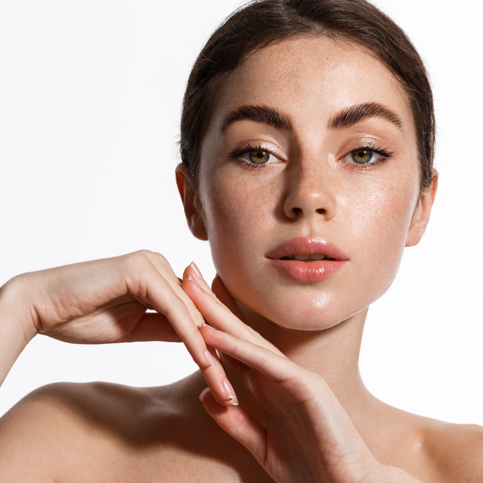 Beauty. Woman 25 years, has shiny glowing skin, clean nourished body and face, looks sensual at camera, eyebrows sick with brow gel, white background