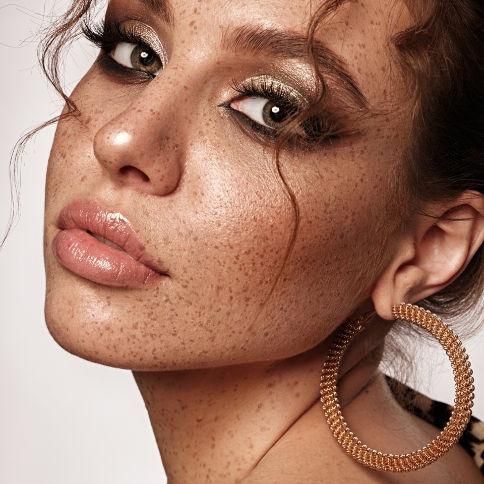Beautiful girl with an unusual hairstyle and creative makeup. Beauty face.