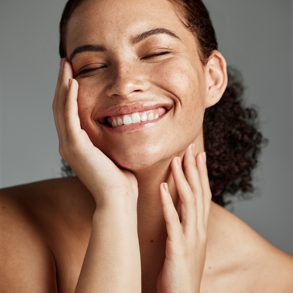 Face, beauty and skincare with a model black woman in studio on a gray background to promote natural care. Facial, wellness and makeup with an attractive young female happy with her skin product