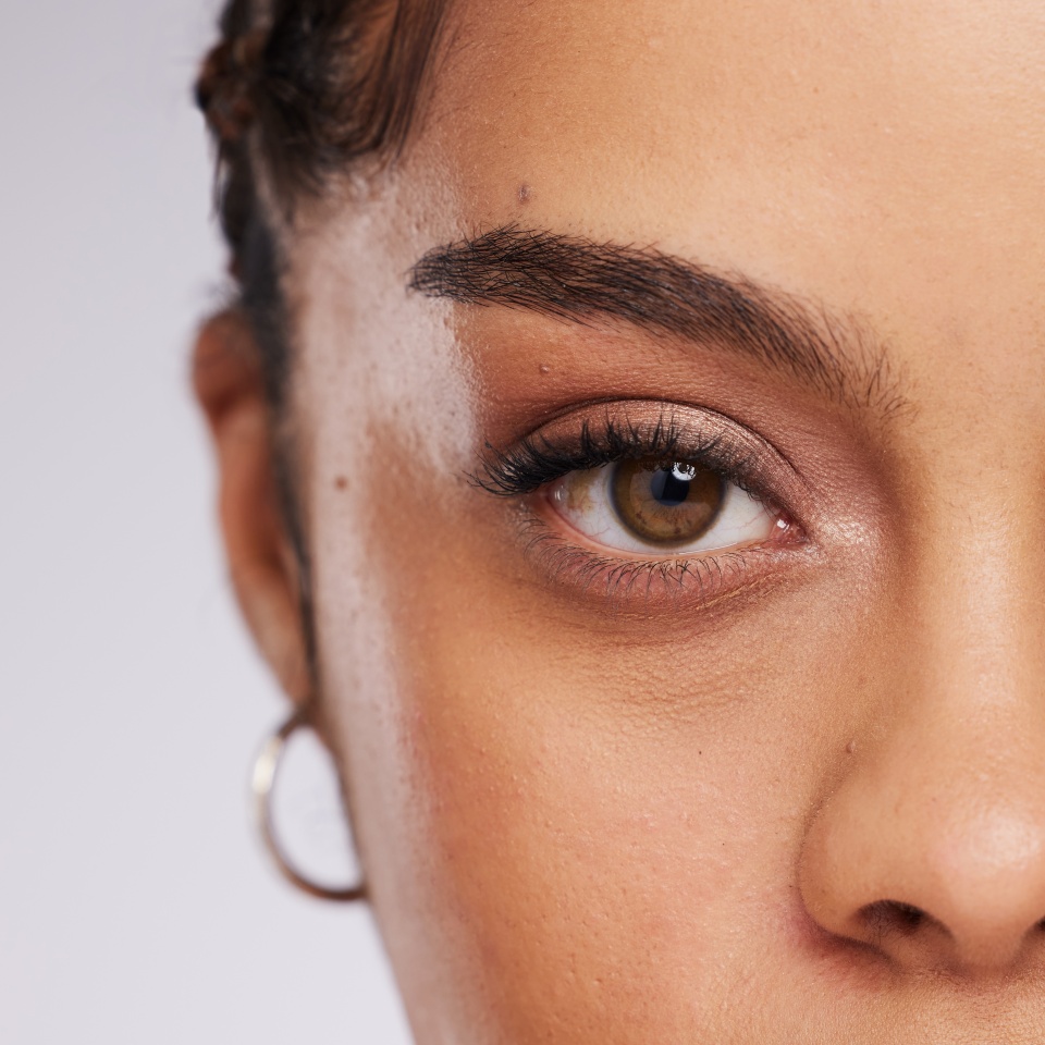 Eye, vision and beauty with contact lens and black woman, care for eyes and cosmetics with closeup on studio background. Microblading, eyebrow and lashes, face and skin in portrait with mockup space