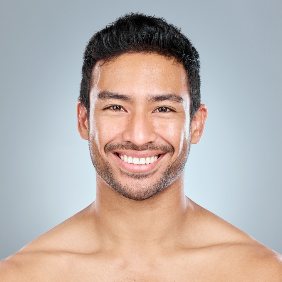 Hes a good looking dude. Shot of a handsome young man posing against a grey background.