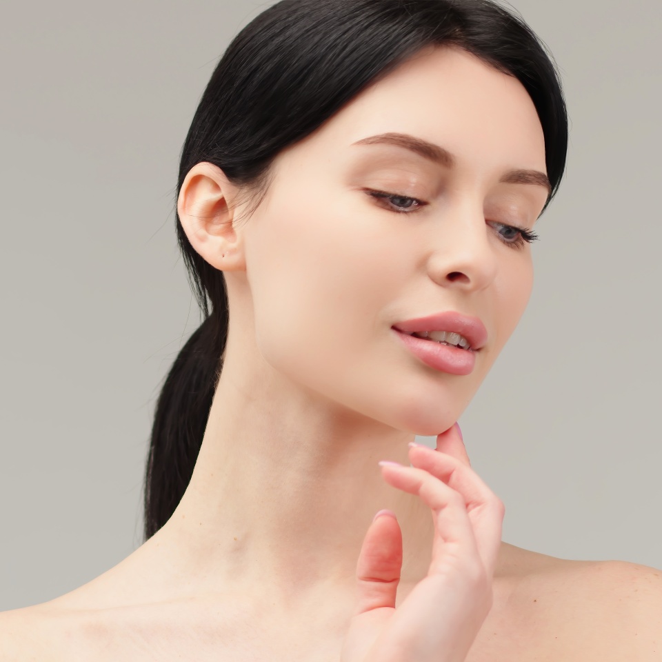 Portrait of a young woman isolated on a light background. Skin care. Beautiful female model with perfectly clean fresh skin. Natural beauty and cosmetology concept
