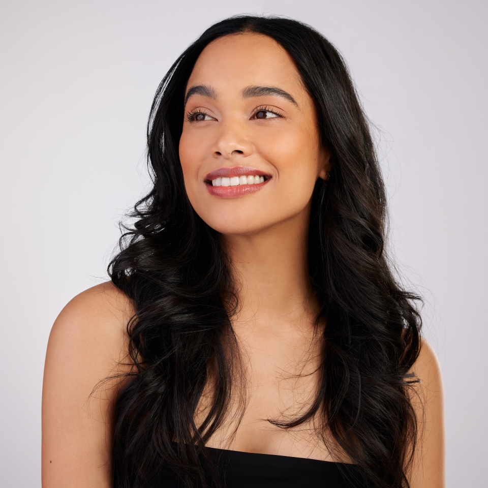 Beauty, thinking and woman with hair care in studio for makeup, glowing skin or keratin treatment on white background. Salon, aesthetic and model with smile for confidence, cosmetics or fresh texture