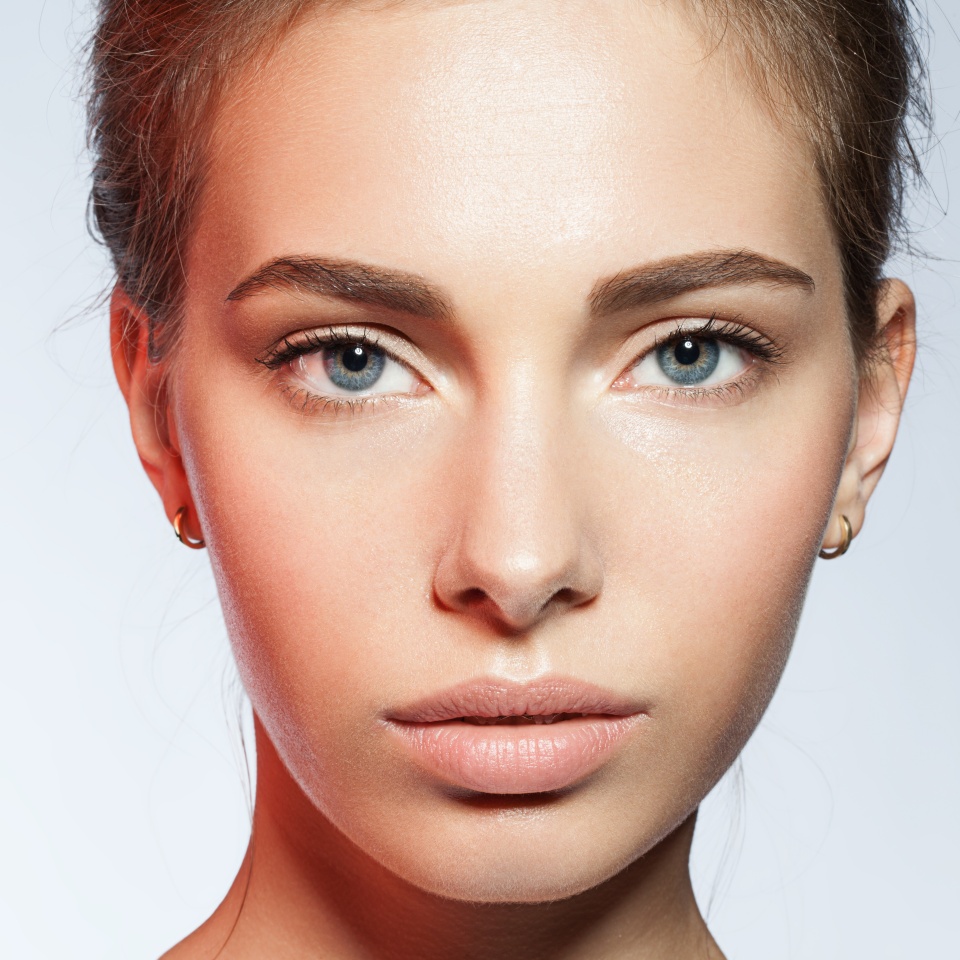 Close-up portrait of young woman with perfect skin clean with a red reflex in the face