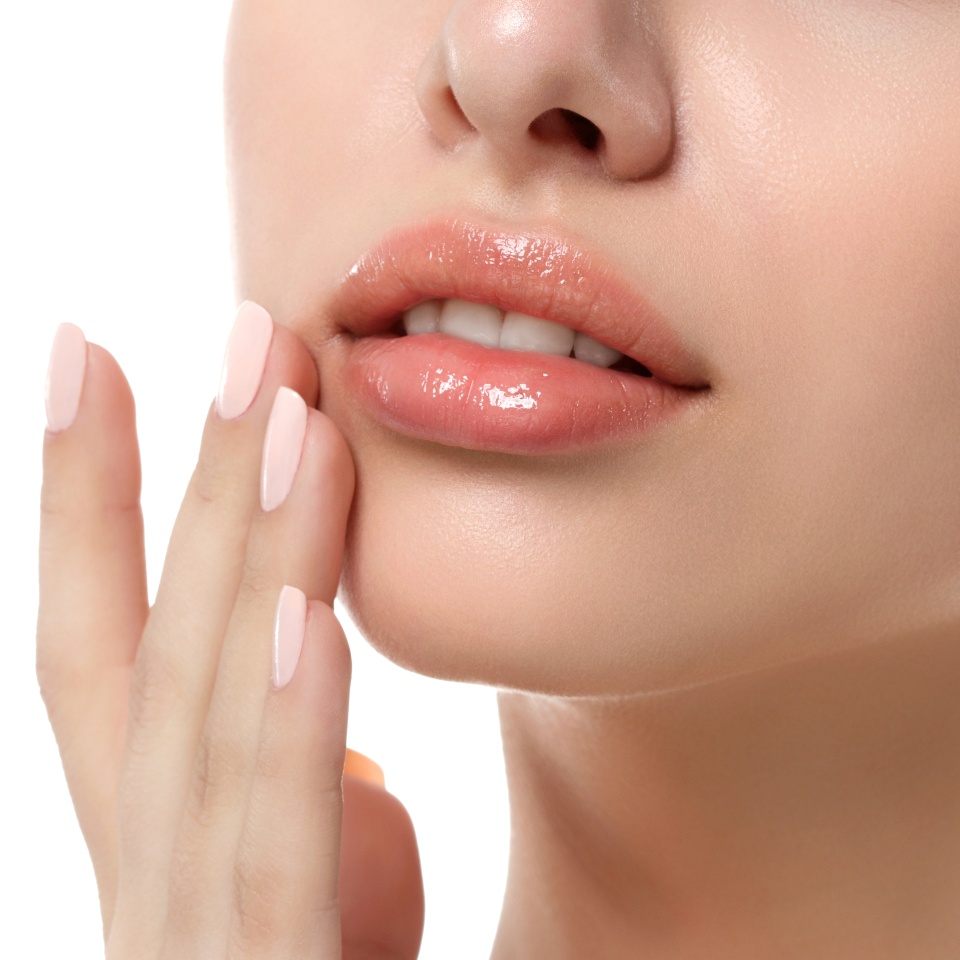 Close up view of young beautiful caucasian woman face isolated over white background. Lips contouring, SPA therapy, skincare, cosmetology and plastic surgery concept