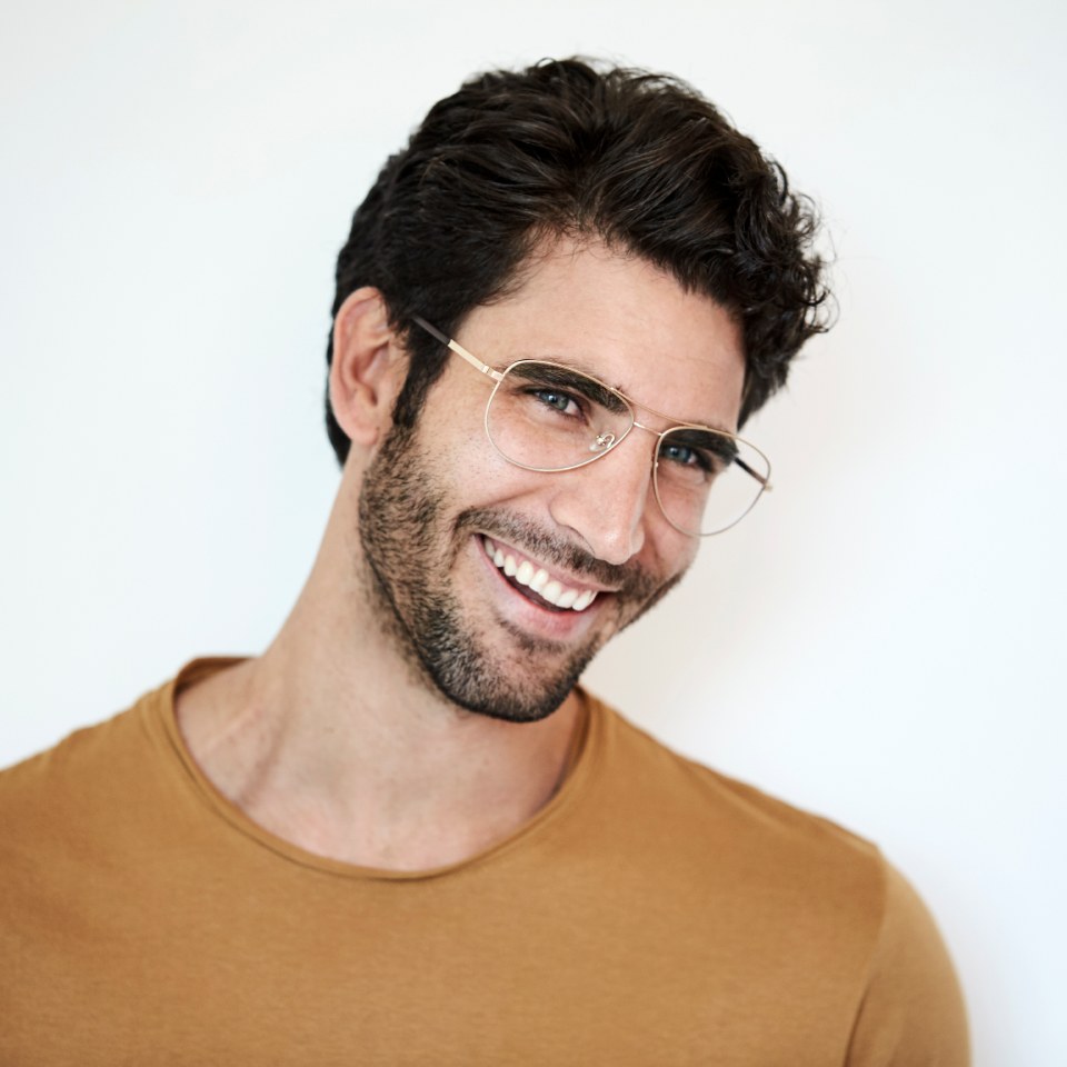 Smiling guy in glasses with beautiful hair against white background.