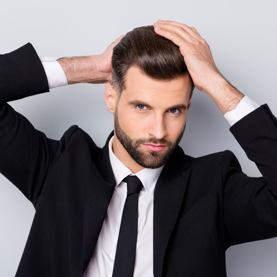 Close up photo of charming man, touch hair 