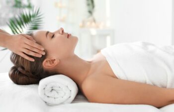 Young woman enjoying massage in spa salon