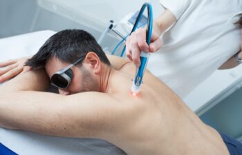 man undergoes laser treatment against skeletal muscle pain, laser can reduce inflammation in damaged tissues, relax muscles, and stimulate nerve regeneration