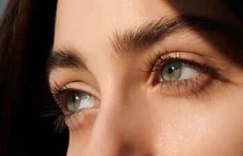 female green eyes with long eyelashes close up. look away