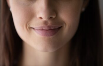Crop close up of beautiful young woman mouth lips without makeup, lower face details, attractive female with healthy perfect clean smooth skin, lip balm, skincare and natural beauty concept