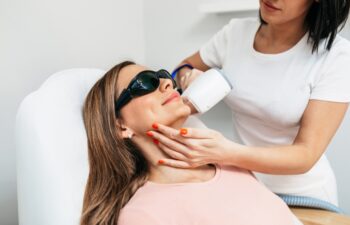 Beautiful woman on laser facial laser hair removal treatment in a beauty salon. Skin care concept.