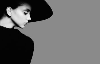 Portrait of beautiful girl in hat in profile, posing in studio, black and white photography