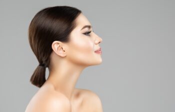 Woman Face Profile. Beautiful Girl with Perfect Nose and Full Lips Side view. Model with smooth Skin over isolated Background. Women Plastic Surgery and Dermal Filler Salon