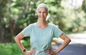 Senior woman, exercise and outdoor for a run, workout and training on road with trees for fitness. Elderly female person happy about cardio for health and wellness while walking or running in summer