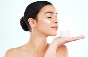 Skinacare, face cream and woman with container in studio isolated on a white background. Lotion, dermatology product and female model with sunscreen, beauty cosmetics or smell healthy skin moisturizer