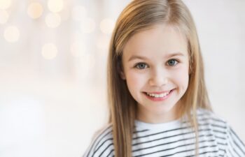 Cute little girl portrait at home. Funny child smiling and looking at camera