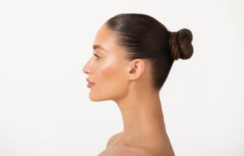 Beauty profile of young European woman with healthy skin natural makeup and perfect nose, lady posing isolated on white background, side view