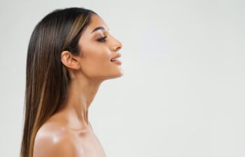 Beauty Girl Face Side View. Beautiful Indian Woman Profile over White. Women Chin and Neck Skin Facelift Massage. Nose Aesthetic Plastic Surgery