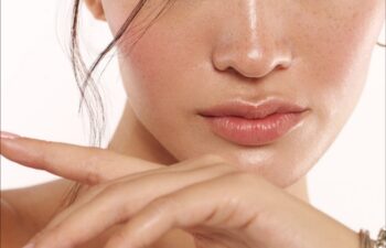 Close up of beautiful young woman's face with clear clear skin and beautiful lips with makeup for skin and body care _ Body and skin care