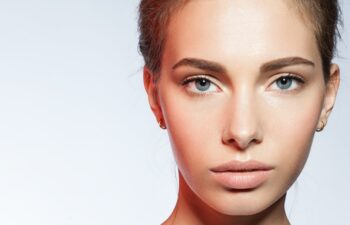 Close-up portrait of young woman with perfect skin clean with a red reflex in the face