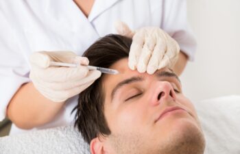 Young Man Having Botox Treatment At Beauty Clinic