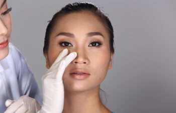Asian Doctor Nurse check face nose structure before plastic surgery and inject beauty chemical syringe to patient, Studio lighting grey background