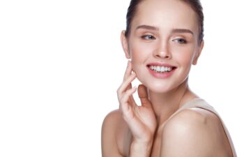 Beauty Cosmetics. Portrait Of Beautiful Smiling Woman Caressing Perfect Soft Skin. Close Up Of Attractive Young Female Model With Professional Natural Makeup. Facial Care. High Resolution